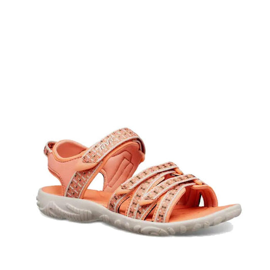 The Teva Girls K Tirra Camino Metallic Rose Gold Sandal (US 11-7, NOT RETURNABLE) features a coral metallic finish, durable webbing upper, adjustable Velcro straps, patterned accents, and a thick textured white sole.