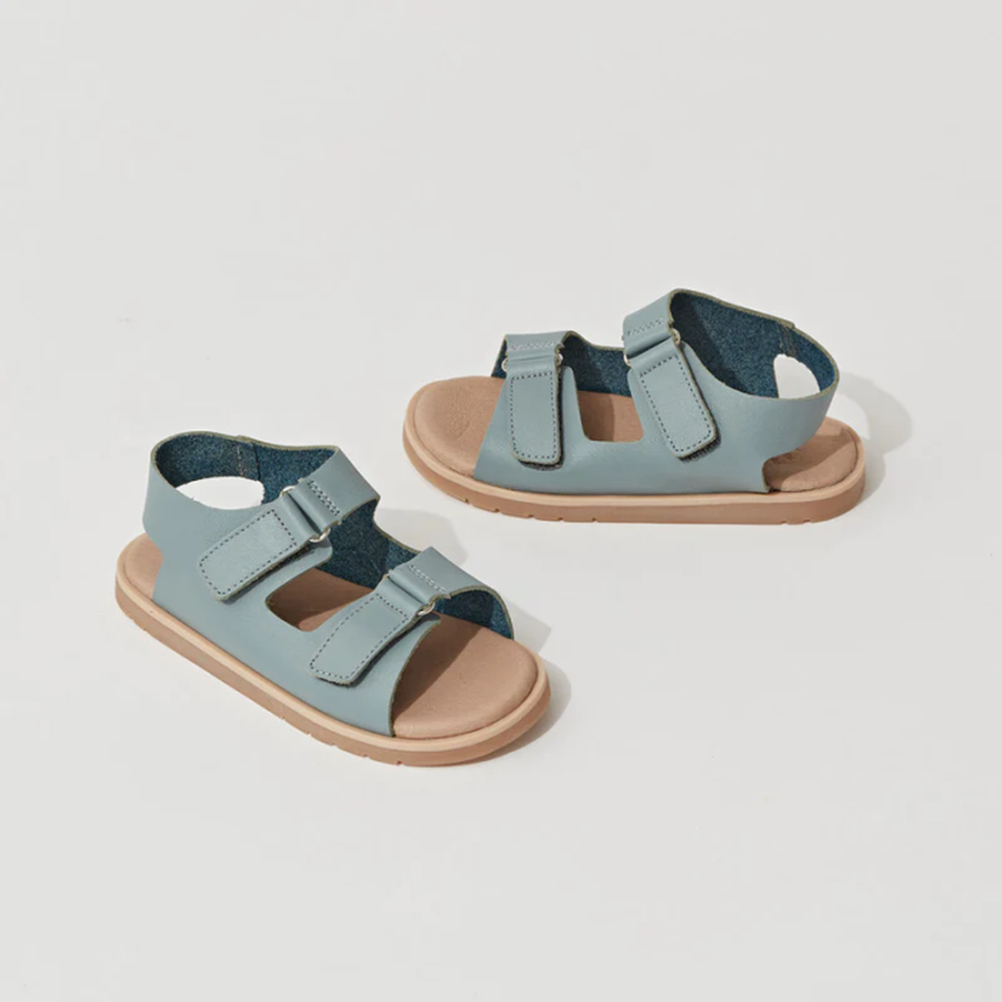 A pair of Pretty Brave WilderSeafoam Blue Kids Sandals (29-31), featuring light blue straps, tan soles, adjustable velcro fastenings, and a lightweight TPR outsole, displayed on a white background. CLEARANCE - NOT RETURNABLE., 9421036359633, 9421036359640