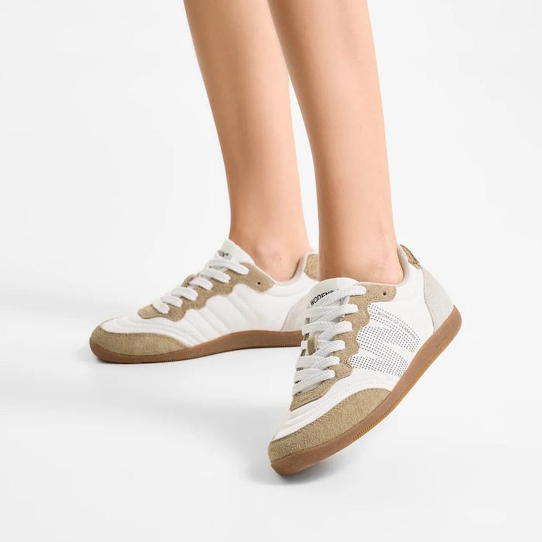 A pair of legs wearing Woden Nanna Blanc De Blance White Lace Up Sneakers, perfect for travel., 50285, 5713326712193, 5713326712209, 5713326712216, 50289