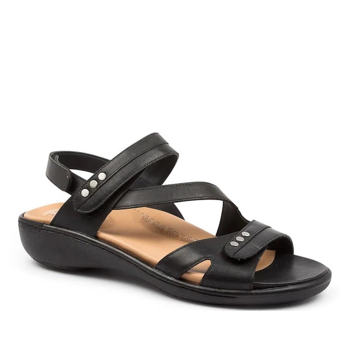 The Ziera Beaux W Wide Women's Black Leather Sandal features a strappy design, low wedge heel, open toe, adjustable ankle strap with silver-tone studs, and a cushioned tan insole for all-day comfort and style.