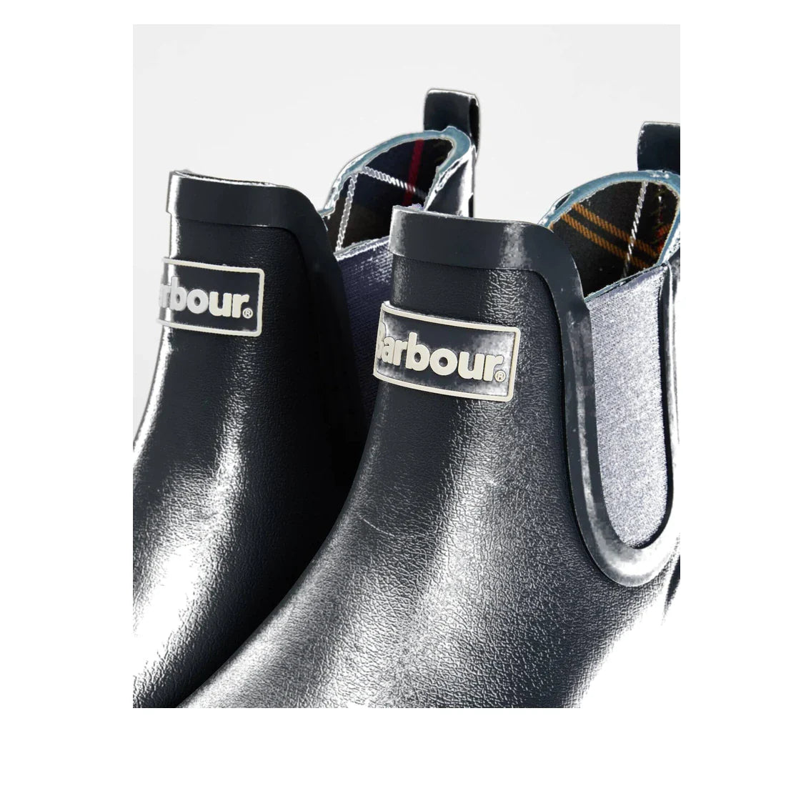 Close-up of two Barbour Wilton Navy Chelsea Wellingtons Womens Rainboots with elastic side panels, tartan linings, Chelsea-boot design, and Barbour logo on the front., 190375411744, 190375411867, 190375412055, 190375412123, 190375412222, 51392