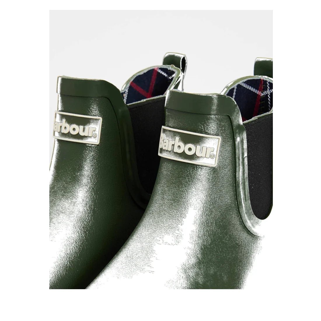 Close-up of glossy Barbour Wilton Olive Chelsea Wellingtons Women's Rainboot, featuring a silver Barbour logo plate, black elastic side panels, and a hint of Barbour tartan lining visible inside., 190375411737, 190375411898, 190375411973, 190375412116, 19