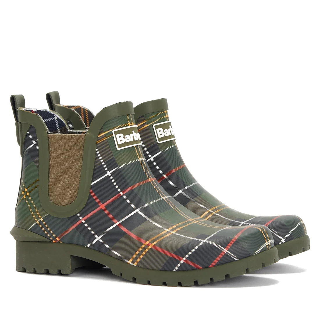 The Barbour Wilton Classic Tartan Chelsea Wellingtons Women's Rainboot features a multicolored plaid pattern, green soles and trim, elastic side panels, and the Barbour label on the front of each ankle boot.