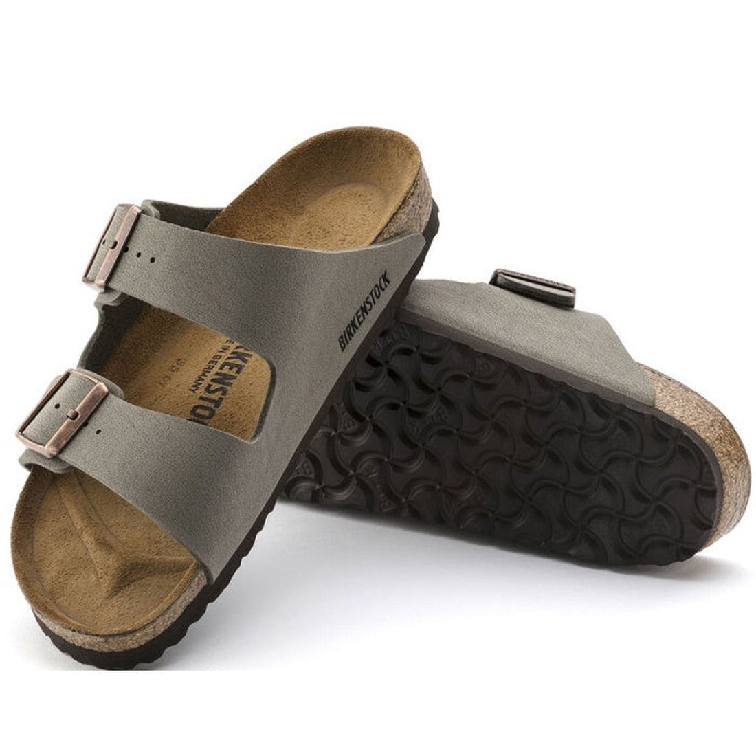 A pair of Birkenstock Arizona Birkibuc Stone Narrow Width sandals with two adjustable buckles, a contoured cork-latex footbed, and one sandal on its side highlighting the textured sole.