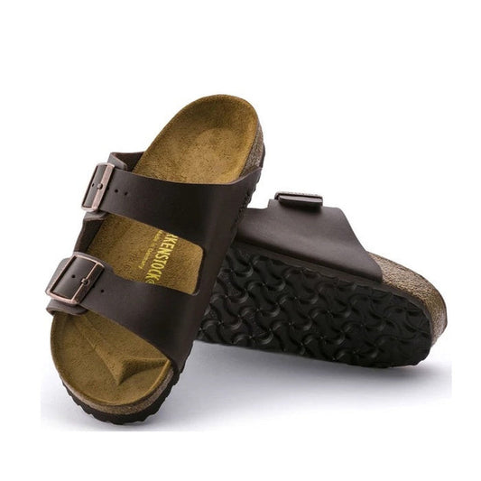 a pair of Birkenstock Arizona Birko Flor Dark Brown Regular Width with double straps, one over the foot and one over the toes with buckle adjustment. Staps are linked at the sides of the foot. Synthetic straps and a suede leather footbed,