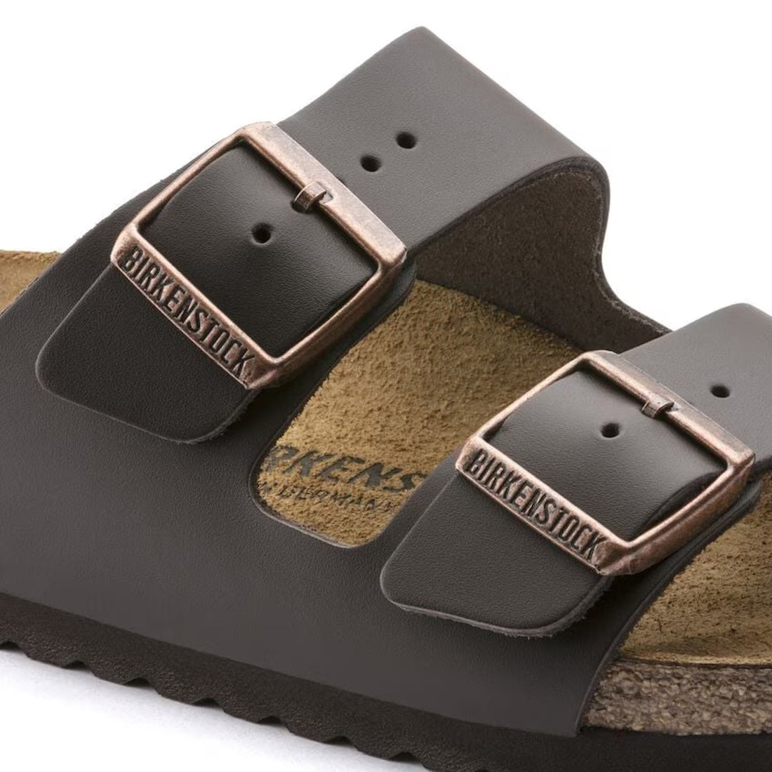 Close-up of a BIRKENSTOCK Arizona Smooth Leather Dark Brown sandal (Regular Width) with two wide straps, adjustable bronze buckles, and part of the cork-latex footbed and textured rubber sole visible.,
4013871066453,
4013871069898,
4013871076551,
40138710