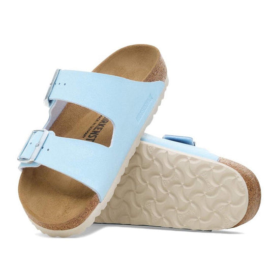 A pair of Birkenstock Arizona Finished Sky Blue Birkibuc sandals (Regular Fit) with two buckled straps, classic cork-latex footbed, and white textured soles. One sandal stands upright; the other leans to show the sole.