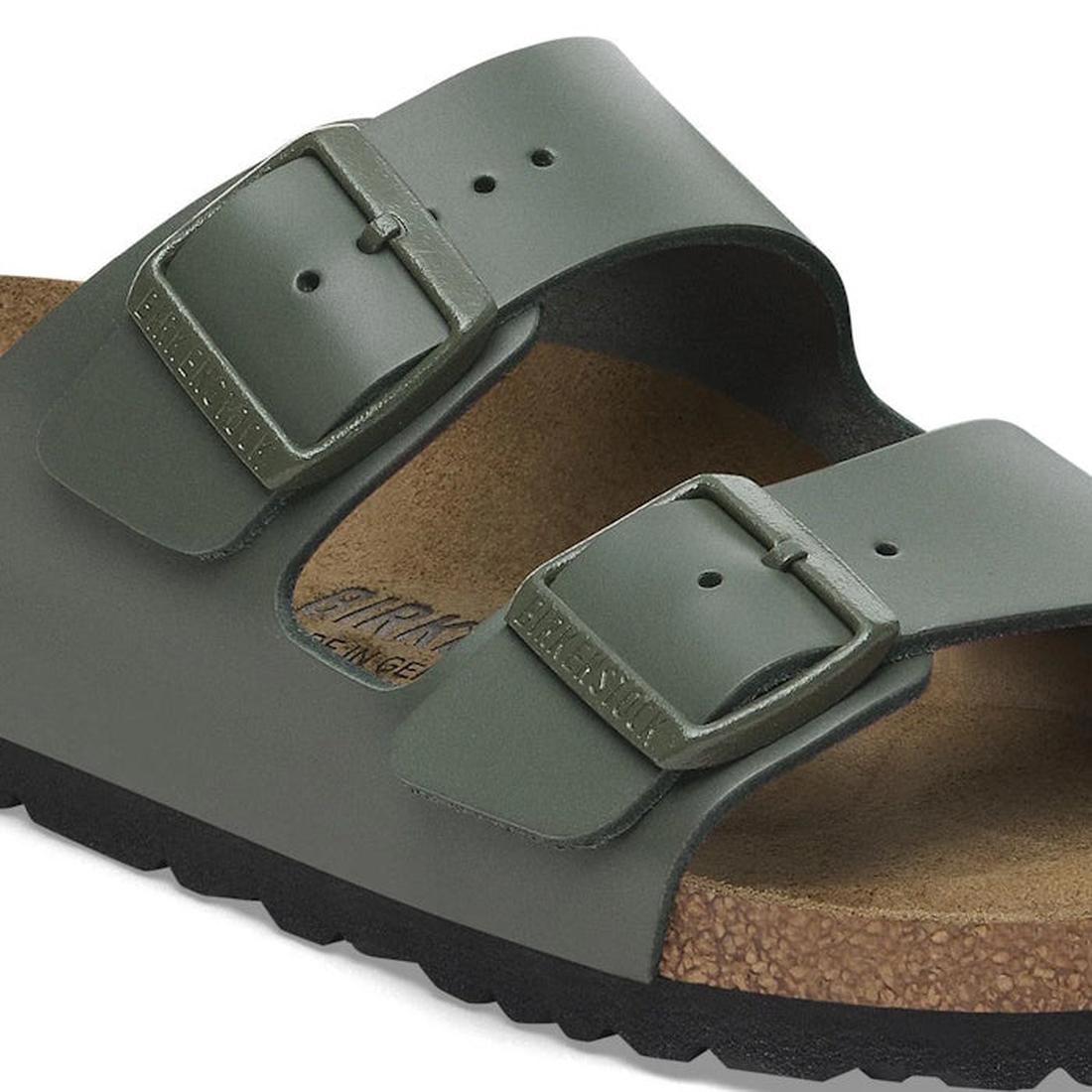 A close-up of the Birkenstock Arizona Smooth Leather Thyme sandal, Regular Width, featuring green adjustable two-strap uppers with metal buckles, a cork footbed, and a black sole., 45282, 45283, 45284, 4066648927563, 4066648927600, 4066648927648, 40666489