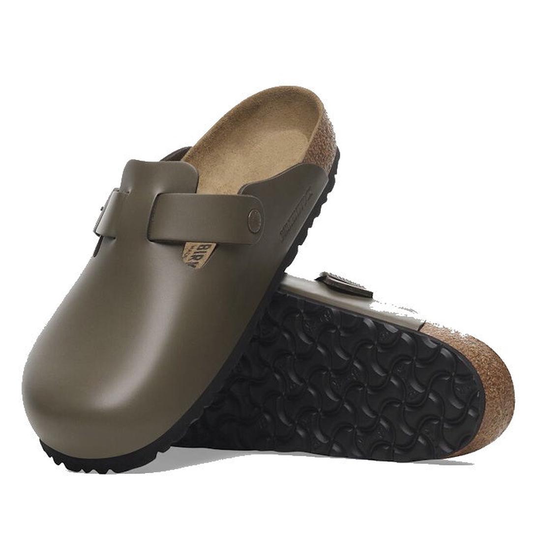 A pair of Birkenstock Boston Clog Smooth Leather Regular in Concrete Grey Dark, featuring slip-on style, contoured cork-latex footbed, and black textured rubber soles. One clog is flat while the other displays the patterned sole.