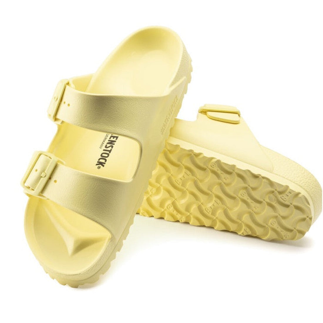 a pair of Birkenstock Arizona EVA Popcorn Yellow Narrow Width with double straps, one over the foot and one over the toes with buckle adjustment. Staps are linked at the sides of the foot. Made of EVA a plastic like material, suitable fot being around wat