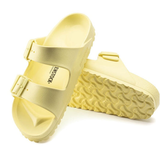 a pair of Birkenstock Arizona EVA Popcorn Yellow Narrow Width with double straps, one over the foot and one over the toes with buckle adjustment. Staps are linked at the sides of the foot. Made of EVA a plastic like material, suitable fot being around wat