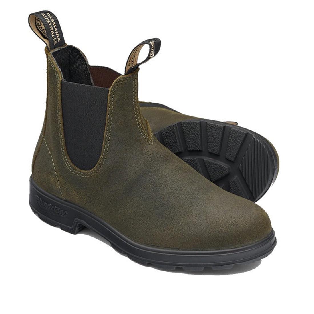 A pair of Blundstone 1615 Chelsea Boots in dark olive green suede with pull tabs and black elastic side panels. Crafted from water-resistant material, they feature textured black soles for grip, positioned with one boot upright and the other on its side t