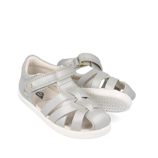 The Bobux Iwalk IW Tropicana II Metallic Silver Sandal 638320 features a woven front, white soles, Velcro strap, and side ventilation—perfect summer shoes for kids.