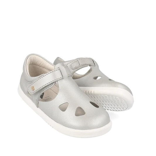 A pair of Bobux IWalk IW Zap II Sandal Metallic Silver kids' sandals with a closed-toe design, cut-out shapes, white rubber sole, and adjustable Velcro straps, displayed on a white background.