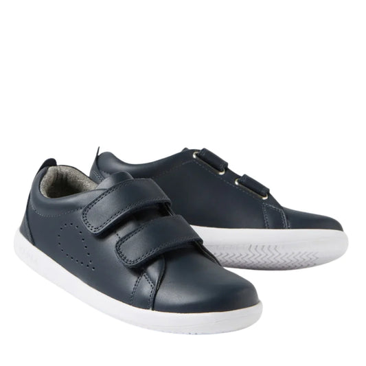 The Bobux KP Kids Plus Grass Court 2 II Leather Sneaker in navy features white soles and two adjustable Velcro straps per shoe, shown against a white background.