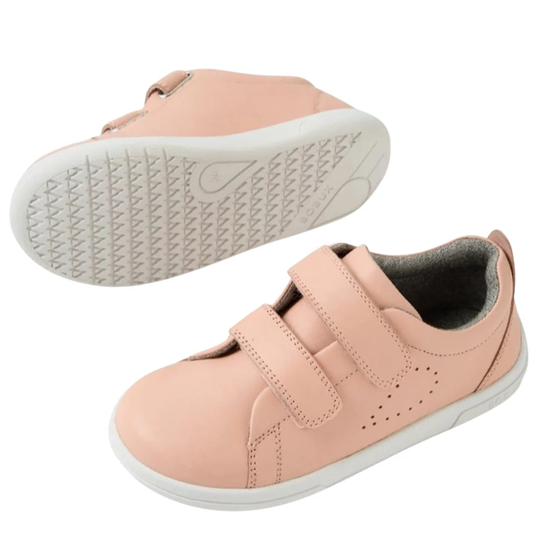 The Bobux KP Kids Plus Grass Court 2 II Leather Sneaker in Seashell features pink leather, white soles, two adjustable Velcro straps, and small side perforations. One shoe is shown from the side, the other displays its textured sole., 9420074831538, 94200