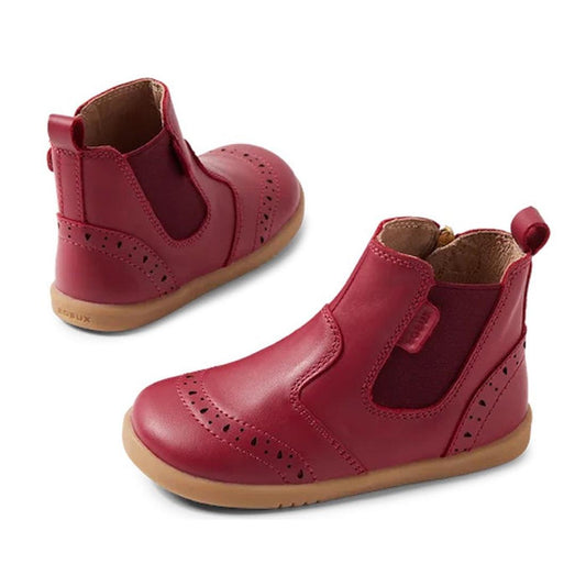 The Bobux Iwalk Billie Toddlers Leather Boot in Tibitan Red (652004) features red leather, brown rubber soles, decorative perforations, side elastic panels, and back pull tabs.