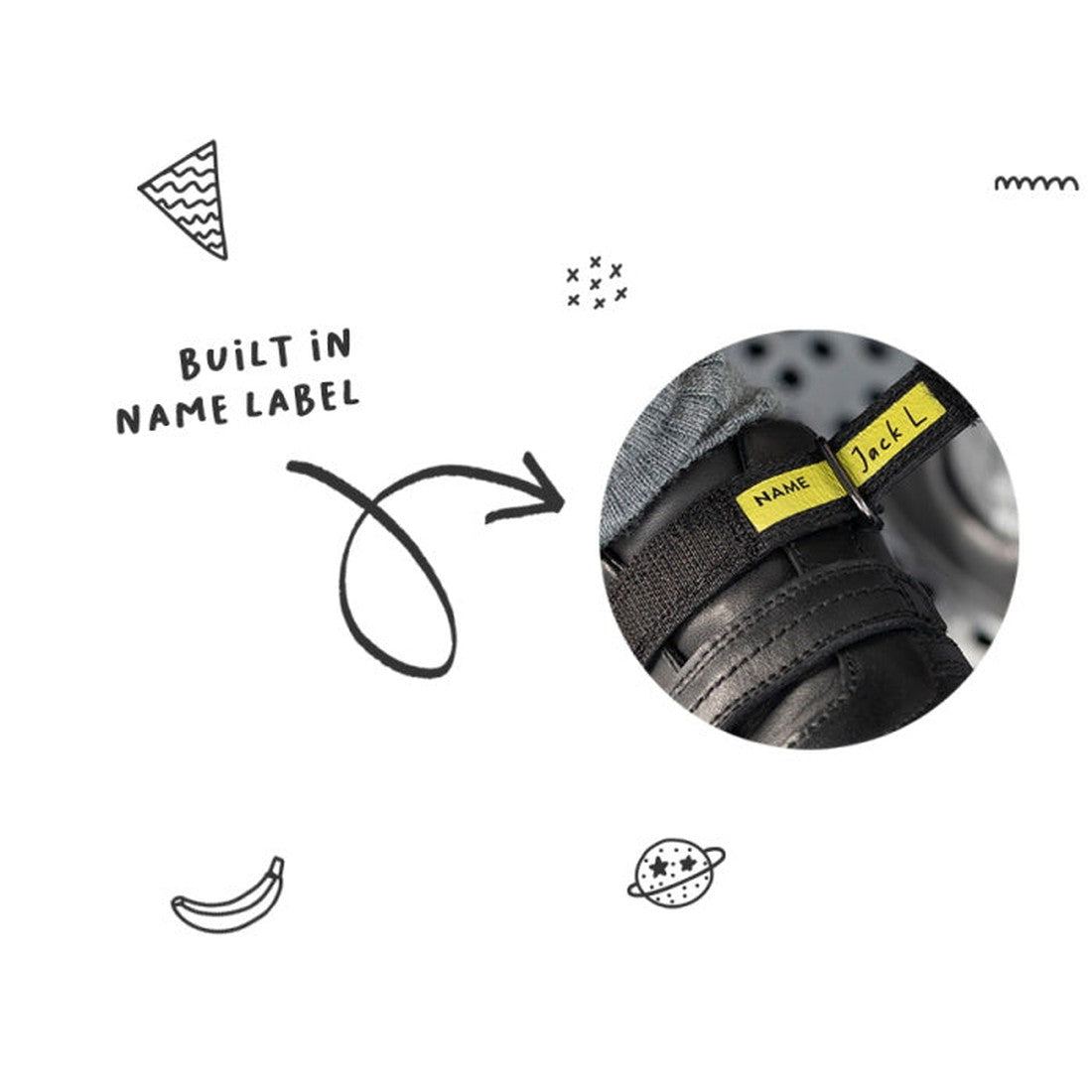 Close-up of the Bobux Kid+ Black School Leather Shoe Venture Trainer with a yellow built-in name label handwritten "Jack L." on the black leather. White background with doodles and "BUILT IN NAME LABEL." Non-marking rubber sole for daily use., 94200685102