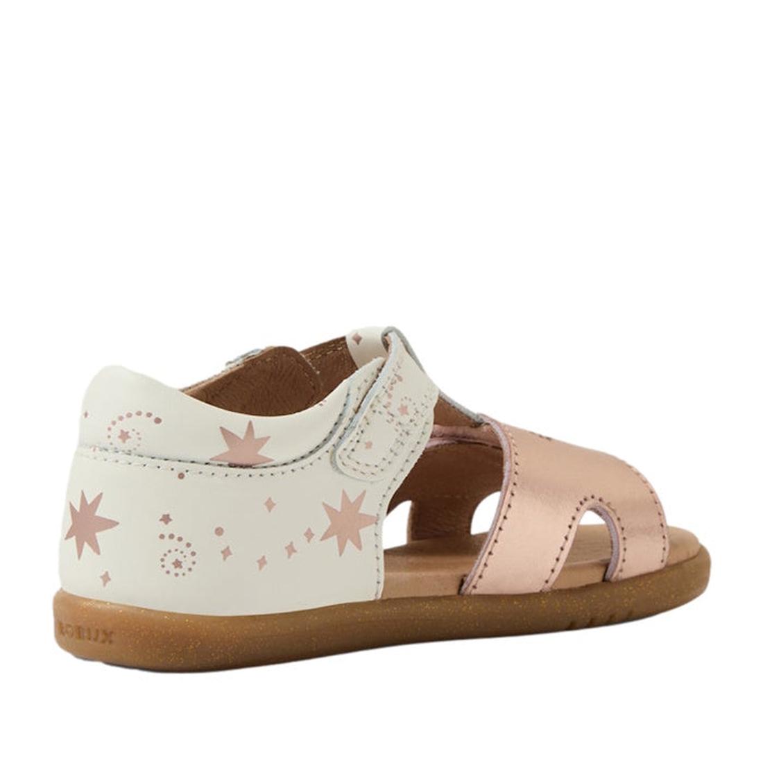 The Bobux IW Iwalk Haven white Rose Gold Open Toe Sandal features a soft brown flexible sole, white heel and strap with pink stars and dots, metallic rose gold front straps, an open toe, and a secure hook-and-loop closure., 9420074865779, 9420074865786, 9