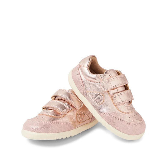 Bobux Step Up SU Champ Sneaker First Walker Rose Gold 750510—shiny rose gold leather baby sneakers with white soles and two Velcro straps, one leaning against the other on a white background.