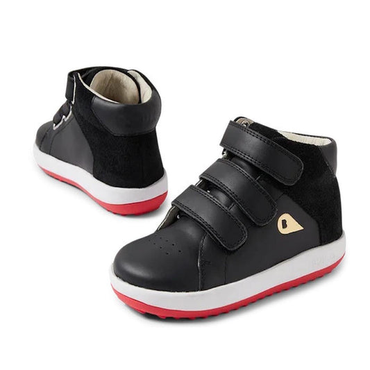 The Bobux Iwalk Gamepoint Toddlers Leather Boot Black 652302 is a black unisex kids' high-top boot with triple Velcro fastening, white soles, and red outsoles. One boot faces forward while the other shows the back and side.
