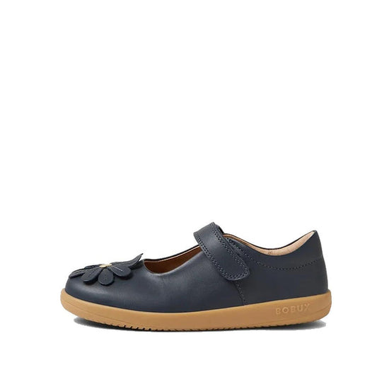 A single Bobux Iwalk Pixie Toddlers Mary Jane Navy Leather 652502 shoe with a tan rubber sole, Velcro strap, and decorative flower on the toe. "BOBUX" is embossed on the side of the sole.