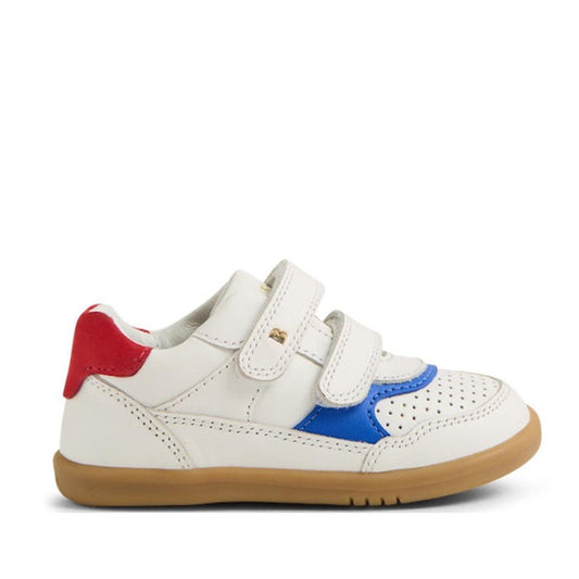 The Bobux IW Iwalk Hunter Leather Sneaker White Salsa is a kids' white leather sneaker with two adjustable straps, a tan rubber sole, blue and red accents, and perforated details on the toe area.