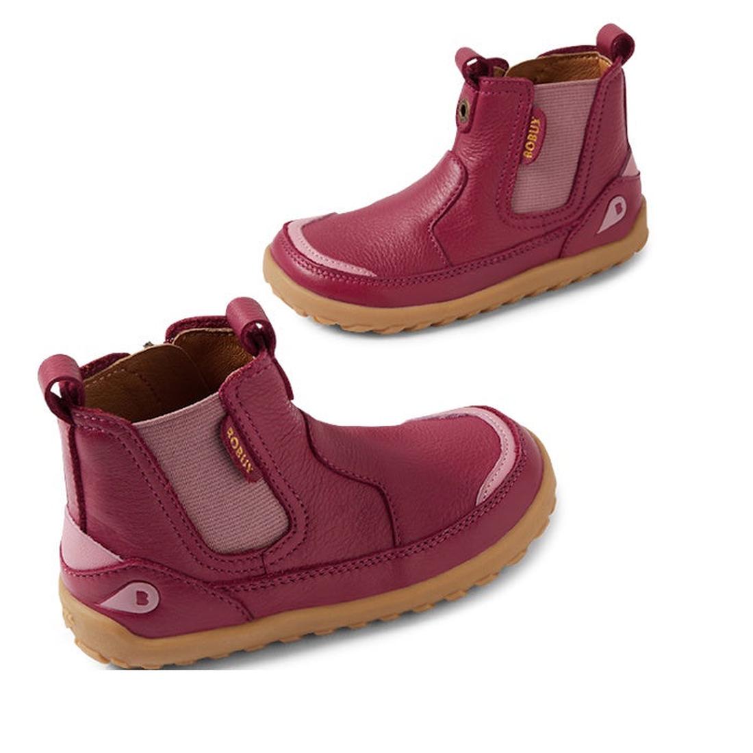 The Bobux IW Iwalk Trail Leather Boot Beaujolias Purple Alpha is a pair of kids' leather boots in dark pink, featuring a barefoot-shaped toe-box, elastic side panels, pull tabs, and light brown rubber soles on a white background.