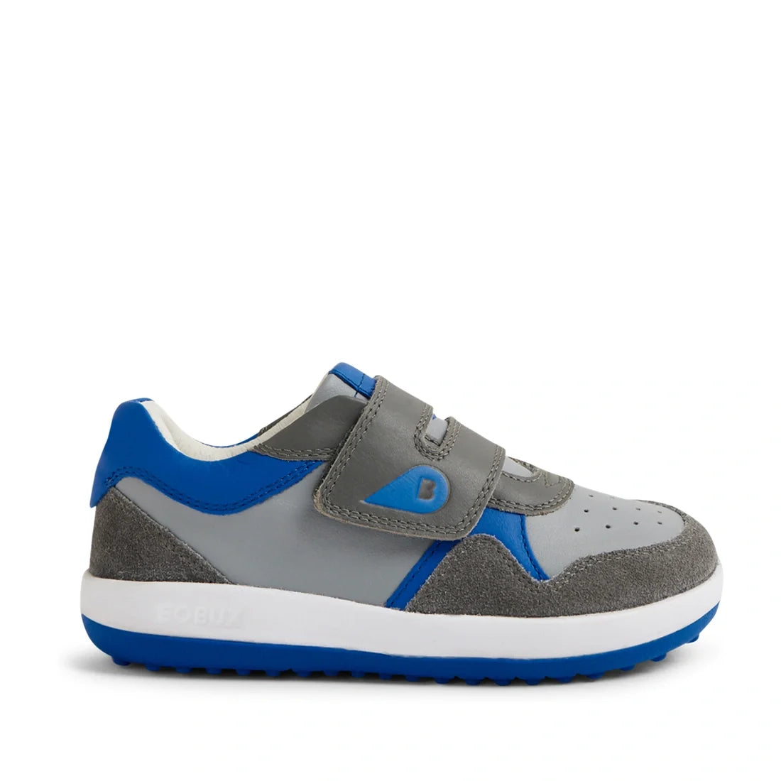 The Bobux IW Iwalk Baseline Leather Sneaker Ultimate Grey is a kids’ leather sneaker in gray and blue, featuring cushioned EVA midsoles, easy hook-and-loop strap closures, a white midsole, and a blue outsole, displayed in side profile on a white backgroun