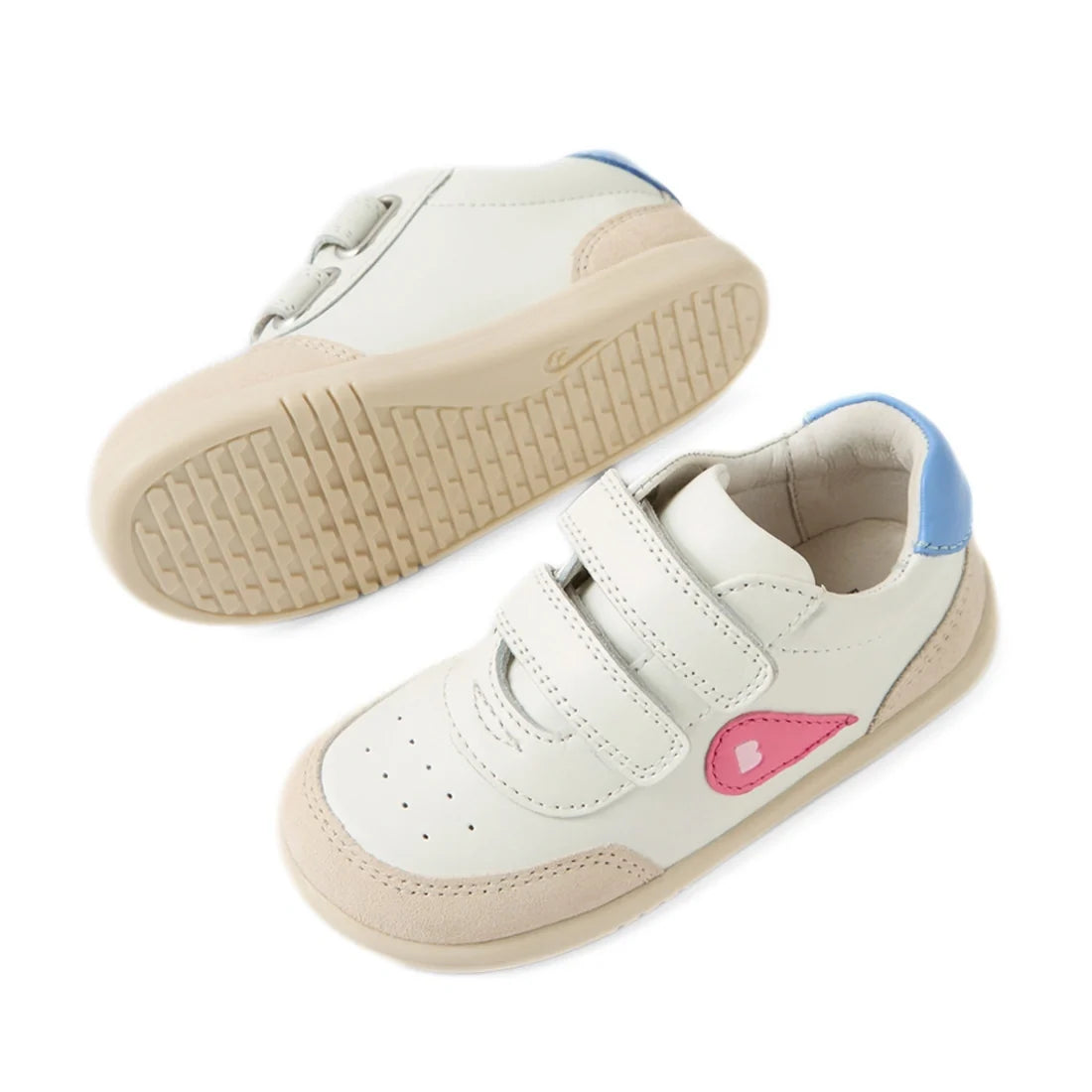 Two Bobux IW Iwalk Toddlers Champ Leather Sneakers in white and pink, featuring beige soles, blue heel accents, a pink side logo, and double hook-and-loop straps. One sneaker stands upright while the other displays its sole., 9420074856654, 9420074856661,