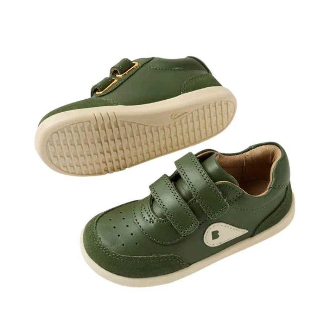 The Bobux IW Iwalk Champ Sneaker Bronze Green features a green design with beige soles, perforated toe detailing, a side logo patch, and two adjustable hook-and-loop Velcro straps for toddler comfort and easy closure., 9420074810786, 9420074810793, 942007