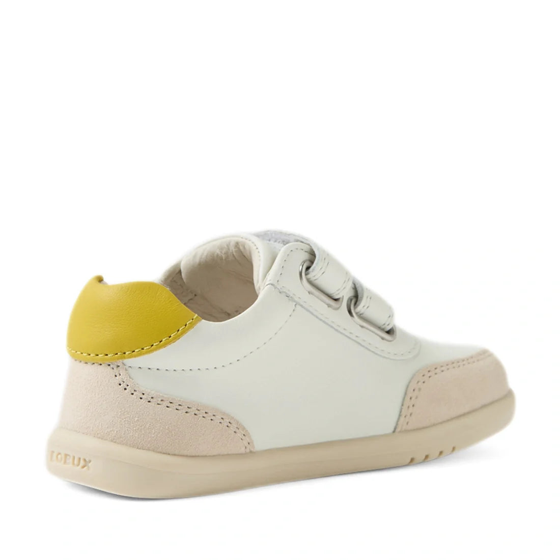 The Bobux IW Iwalk Toddlers Champ Leather Sneaker in White Green is a stylish kids’ leather sneaker featuring a white base with beige suede accents, two hook-and-loop straps, a yellow heel detail, and a light brown sole—shown here from the back left side.