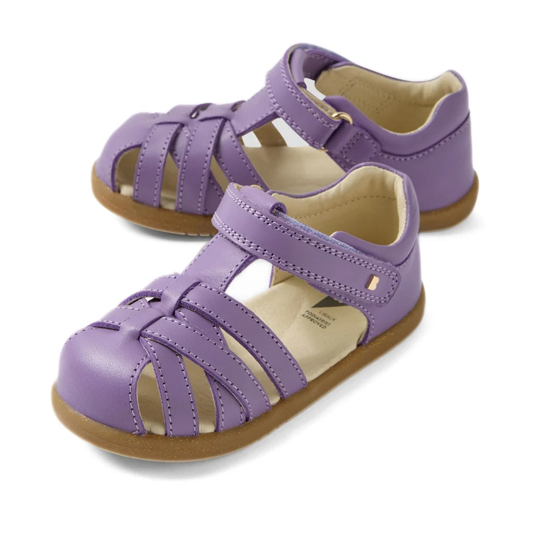 The Bobux Iwalk IW Cross Jump Toddlers Purple Haze Leather Sandals feature closed toes, tan soles, and adjustable velcro ankle straps, providing comfort and support for kids during all-day play.