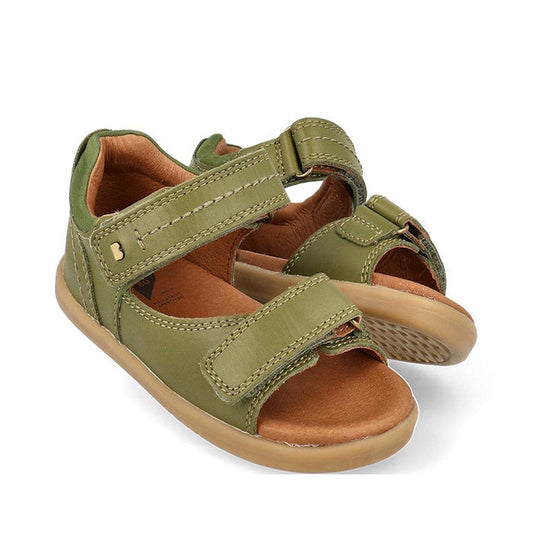 The Bobux Kid+ Plus Driftwood Sea Kelp Green Open Toe Sandal 833518 features olive green leather, tan soles, and adjustable Velcro straps for kids—ideal for boys and shown against a white background.
