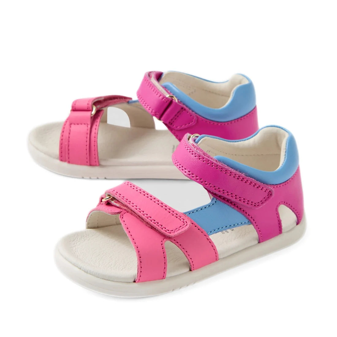 A pair of Bobux IWalk Dune Toddlers Sandal Rose Violet Bright Pink Open Toe, these pink toddler sandals feature blue straps, white soles, and adjustable Velcro closures—making them the perfect leather sandals for toddlers who want both comfort and style.