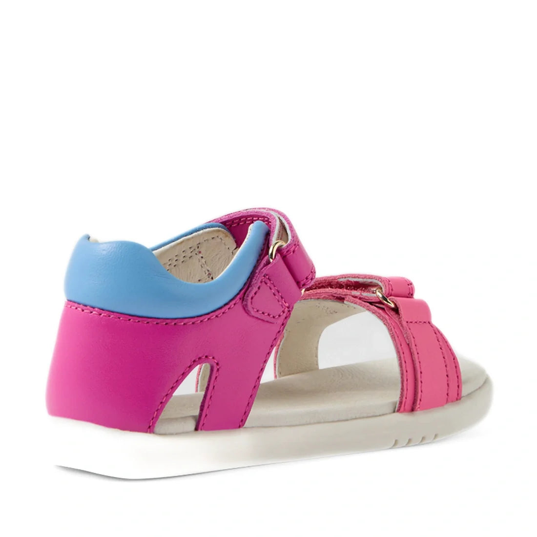 A Bobux IWalk Dune toddlers sandal in Rose Violet Bright Pink with a blue padded heel, white sole, and open-toe design is shown from a back side angle. Crafted from quality leather, this stylish sandal offers durability and comfort for toddlers, making it