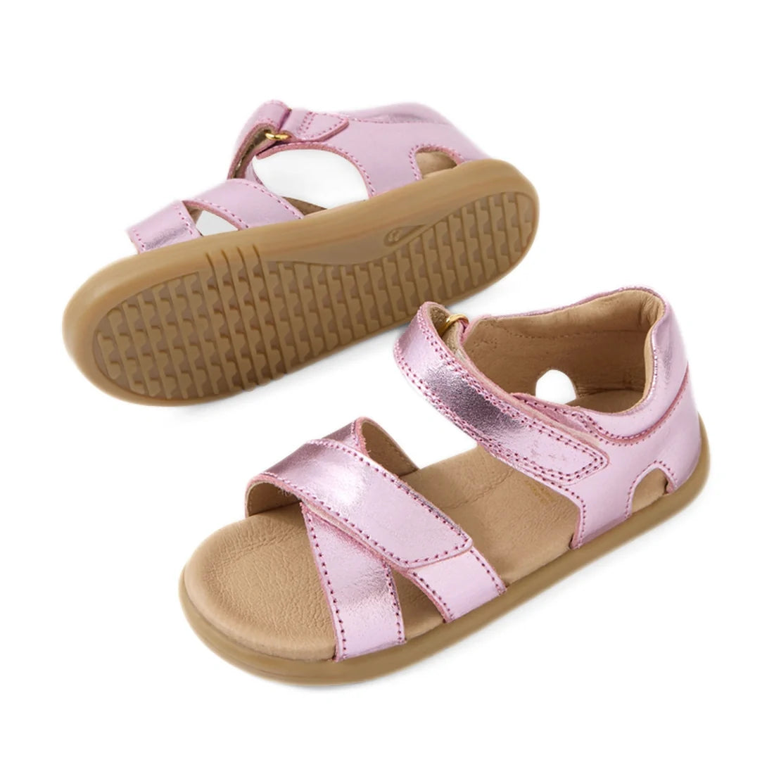 Introducing the Bobux IWalk Flora Toddlers Sandal in Pink Lemonade: a pair of metallic pink open-toe sandals for children, featuring breathable leather uppers, tan rubber soles, and adjustable hook-and-loop straps for a secure fit. Perfectly crafted for t