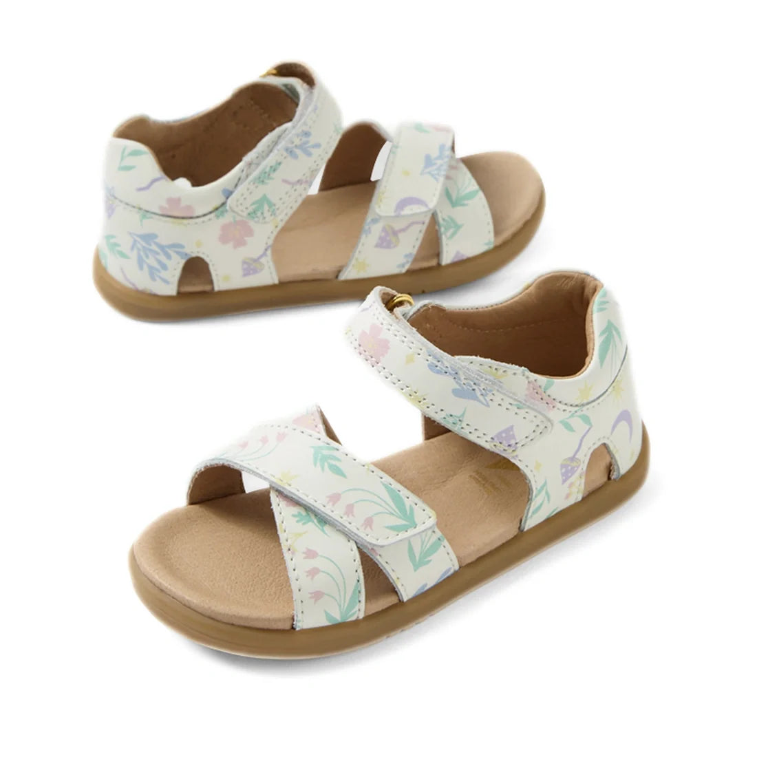Two pairs of Bobux IWalk Flora Toddlers Sandal White Floral Open Toe are displayed, each featuring light-colored soles and white leather straps with a delicate floral pattern and adjustable Velcro closures. Crafted for all-day comfort, one sandal lies fla
