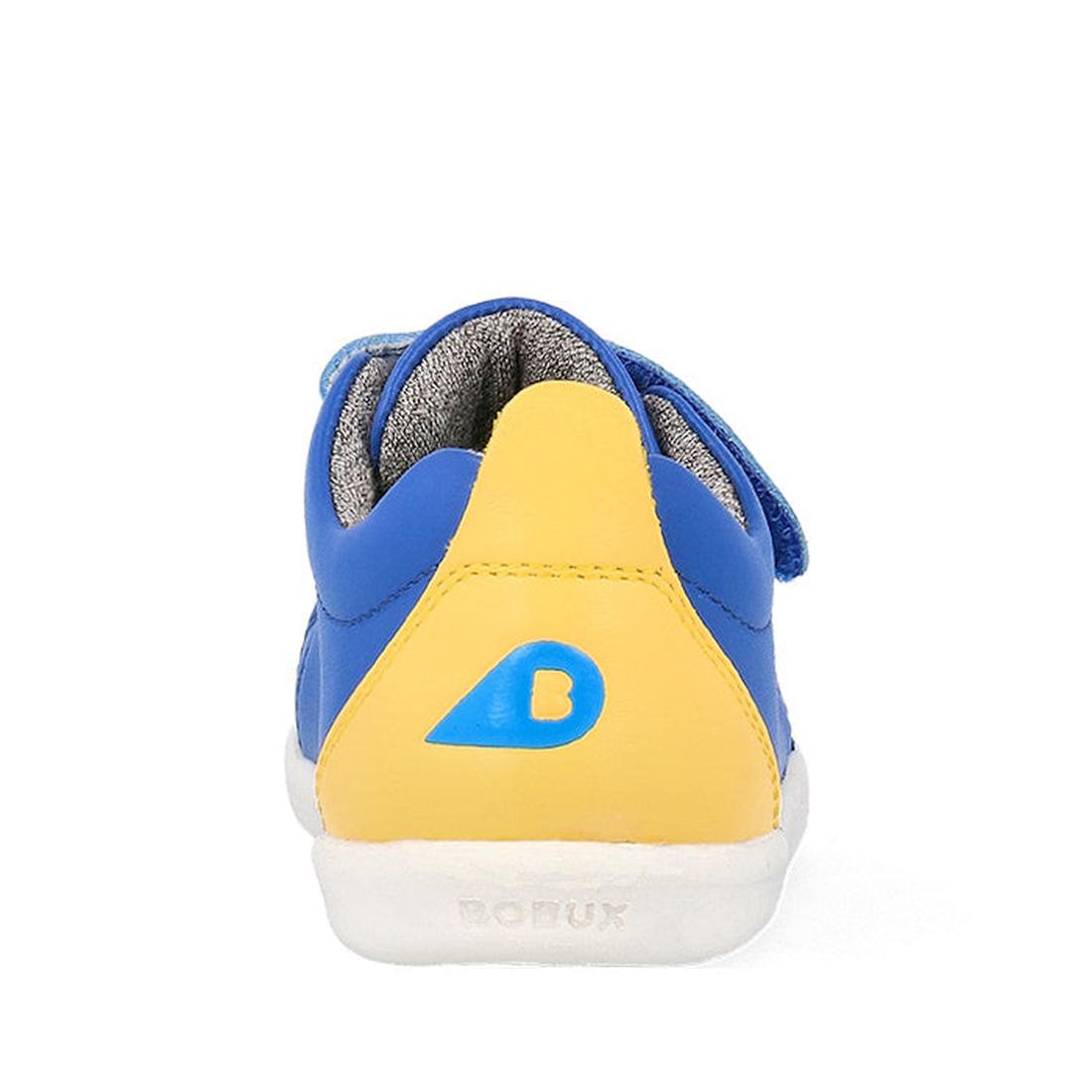 The Bobux Iwalk Grass Court Azzure Blue Leather Trainer 640507 is a child’s unisex sneaker seen from the back, with blue and yellow panels, white sole, blue B logo on yellow heel, premium leather upper, gray lining, and Bobux embossed on the sole., 942007