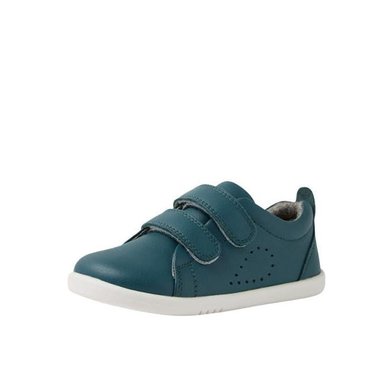 The Bobux IW Iwalk Grass Court Leather Sneaker in Mediterranean Green features a premium leather upper, two velcro straps, white sole, and side perforations for ventilation, combining comfort with street style against a plain white background.