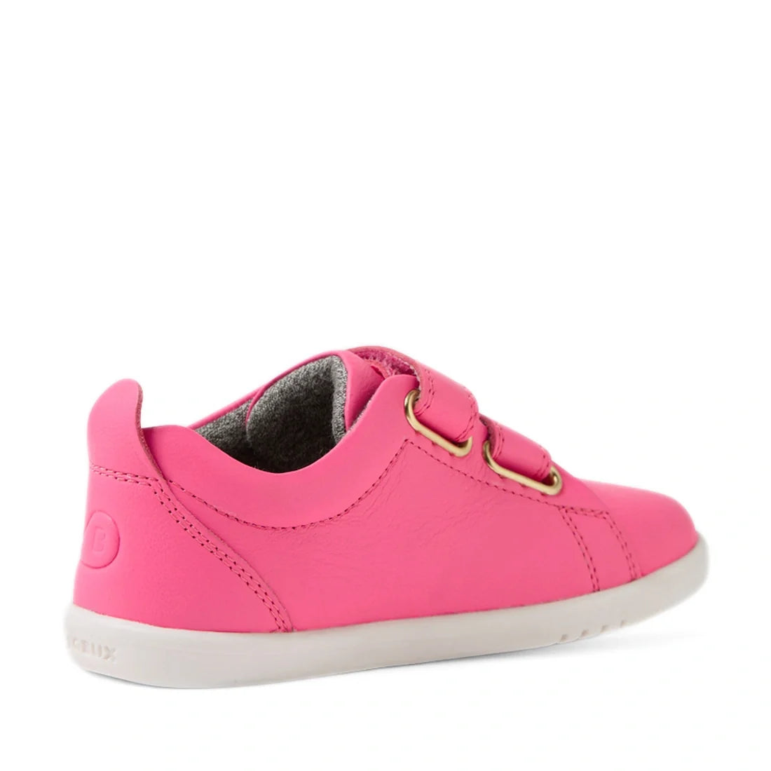 The Bobux Iwalk Toddlers Grass Court Pink Lemonade Leather Trainer, featuring a bright pink leather upper inspired by the classic Grass Court design, two hook-and-loop straps with gold eyelets, a white rubber sole, and a soft inner lining—is shown from th