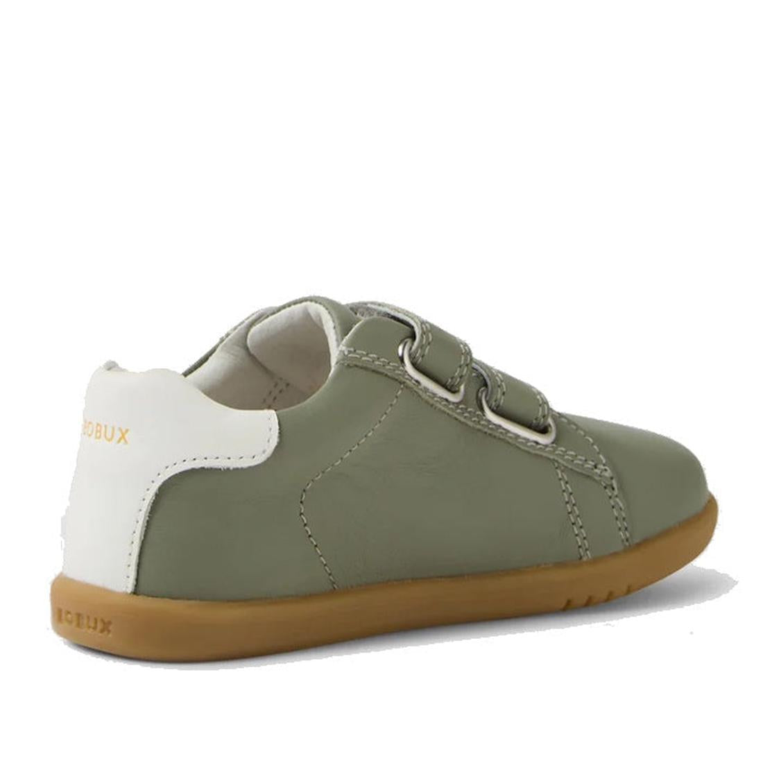 The Bobux IW Iwalk Maverick Leather Sneaker in Vetiver Green features olive green leather, a white heel accent, two adjustable straps, and a light brown rubber sole. Shown from a rear side angle, the shoe is crafted from breathable leather for kids., 9420