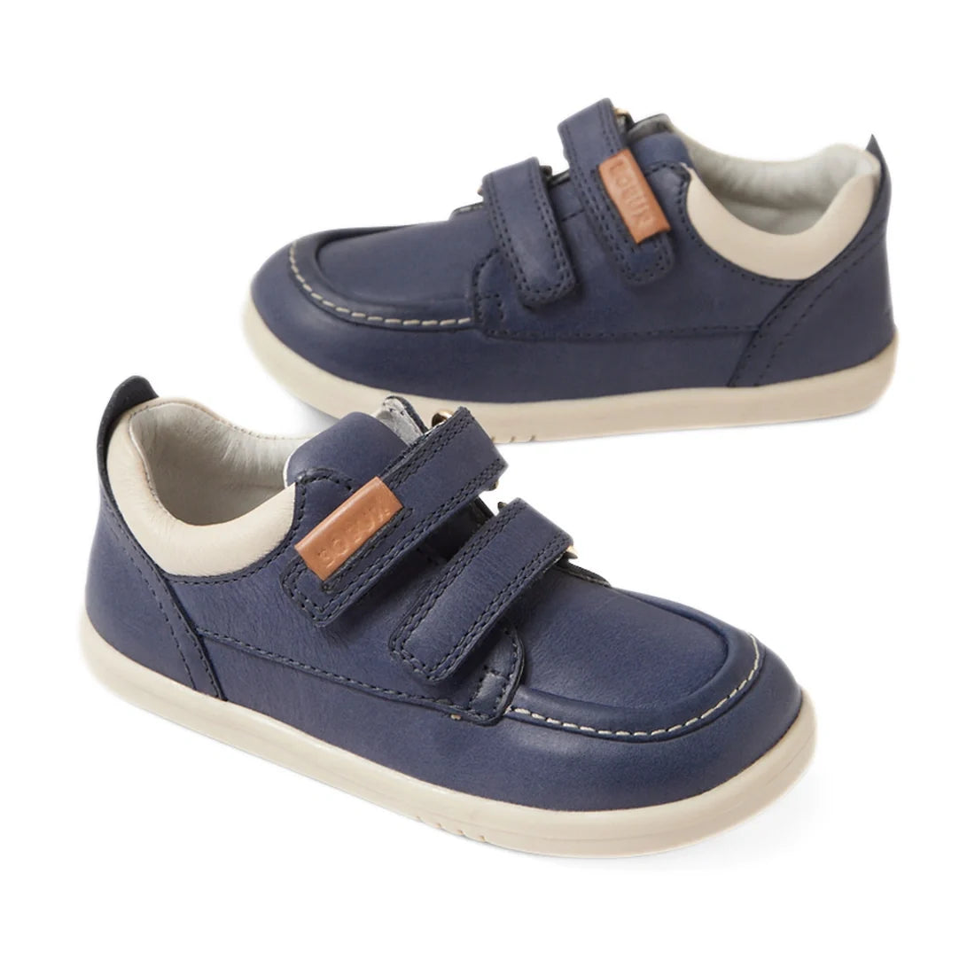 A pair of Bobux IW Iwalk Oakley Toddlers Leather Sneaker in Vintage Blue, featuring a lightweight sole, white accents, beige lining, and two Velcro straps on each shoe.