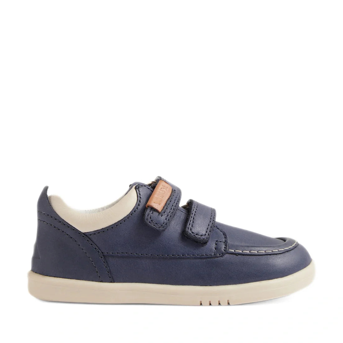 The Bobux IW Iwalk Oakley Toddlers Leather Sneaker in Vintage Blue features a navy blue leather upper, two hook-and-loop straps, white lining, a lightweight beige sole, and visible stitching on the toe area reminiscent of a moccasin boat shoe, shown in si