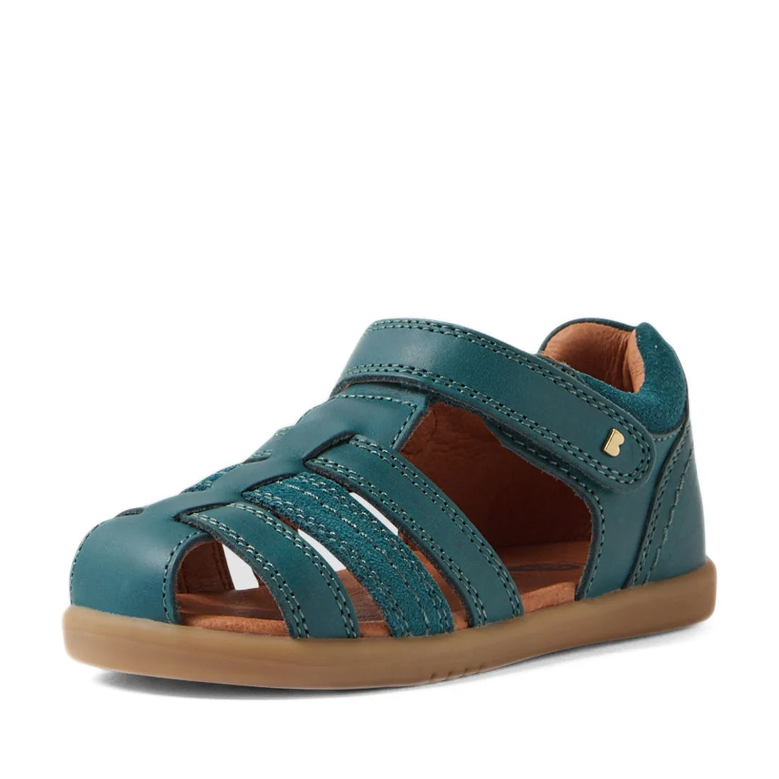 The Bobux IWalk Roam Sandal Mediterranean Green Closed Toe Toddlers is a stylish closed-toe sandal featuring multiple straps, a Velcro closure, and a tan rubber sole. Inspired by the Bobux Roam Toddlers line, these sandals are displayed at an angle agains