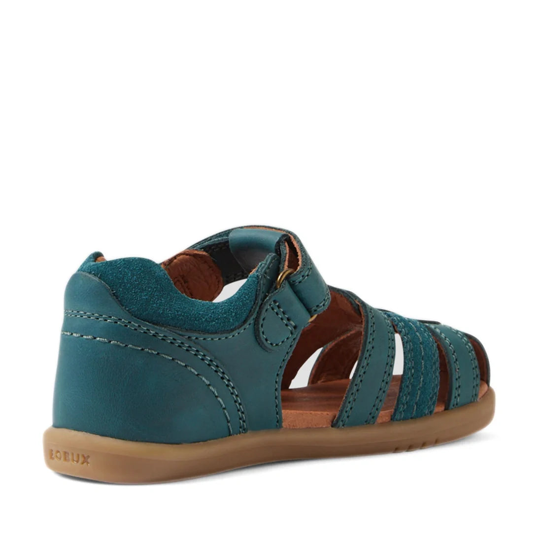 A Mediterranean green leather children’s sandal—like the Bobux IWalk Roam Sandal Closed Toe for toddlers—features a closed heel, open toe, adjustable strap, and brown rubber sole, shown from a back side angle. These stylish closed-toe sandals provide comf