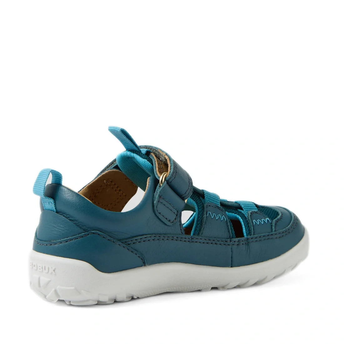 The Bobux IW Iwalk Rocky Mediterranean Green Closed Toe Sandal Barefoot features teal and blue tones, a white rubber sole, side cutouts, velcro strap, and fabric accents—these toddler casual sandals are displayed at an angle showing both the outer side an