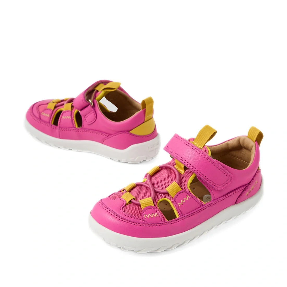 A pair of Bobux IW Iwalk Rocky Rose Violet Bright Pink Closed Toe Sandals for toddlers, featuring white soles, velcro straps, and cutout details.