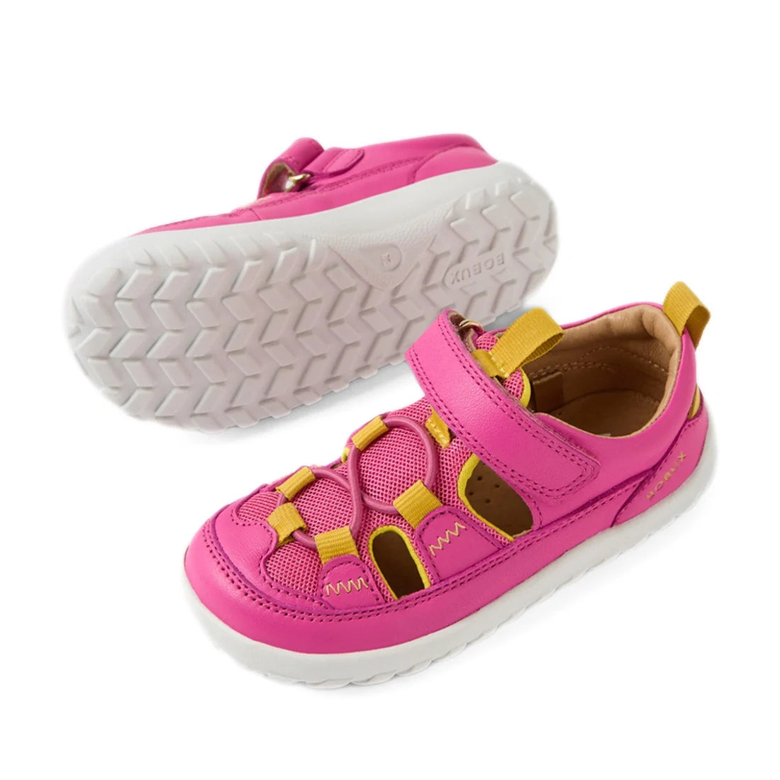 Two Bobux IW Iwalk Rocky Rose Violet Bright Pink Closed Toe Sandals for kids, featuring a playful pink and yellow color scheme with white soles; one sandal is upright while the other lies on its side to highlight the tread pattern and design details—ideal