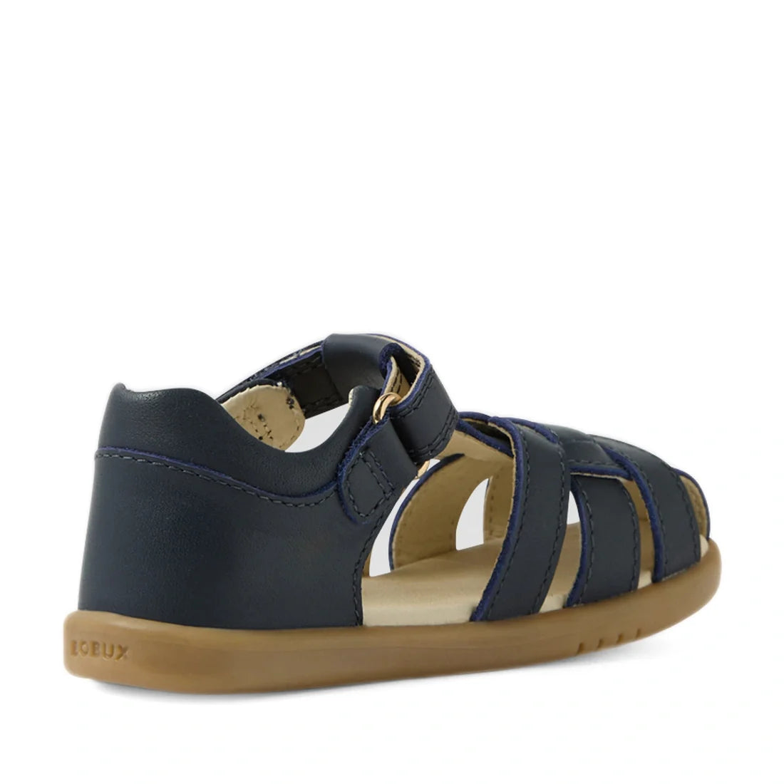 The Bobux IWalk Skip Twist Sandal Navy Closed Toe Toddlers is a navy blue children’s sandal featuring a closed toe, open sides, and a tan rubber sole. Designed in the classic closed-toe sandal style, it includes a convenient hook-and-loop strap and visibl